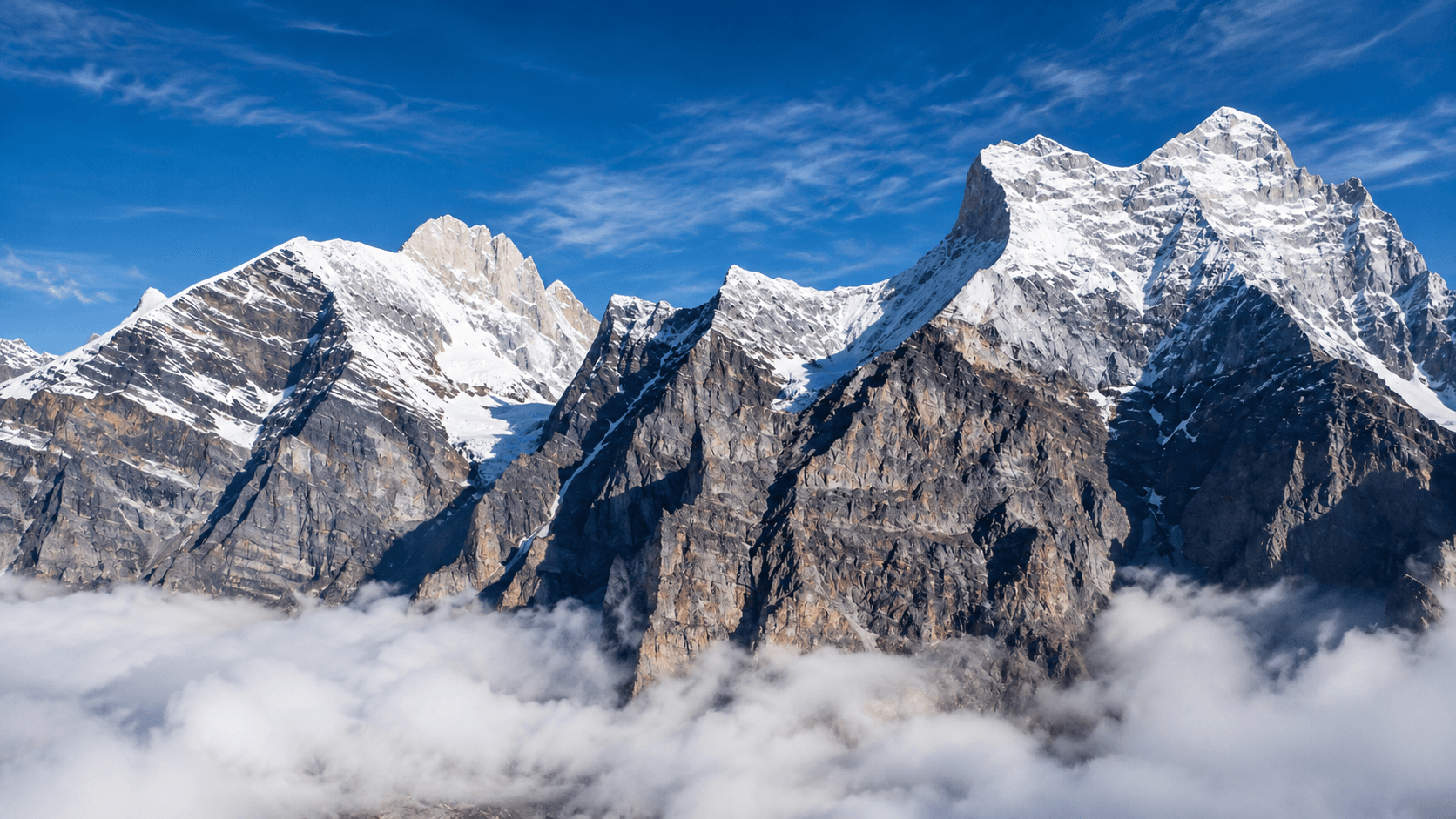 Snow-covered Himalayan peaks rising above the clouds